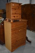 A modern pine chest of five drawers and a similar three drawer bedside chest