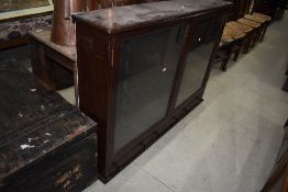 A traditional stained frame display case, previously used for guns, having fitted racks within