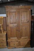 A modern natural pine wardrobe having drawer base, approx. width 122cm depth 63cm height 204cm,