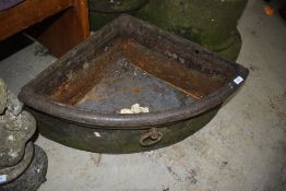 A cast iron corner trough, with ring handle to front