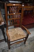 A traditional elm Lancashire style spindle back armchair having rush seat