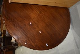 A Victorian mahogany snap top dining table on turned column and triple splay legs
