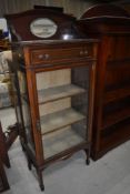 An Edwardian mahogany and inlaid narrow display cabinet having mirror back and frieze drawer,