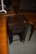 An Oriental hardwood nest of four tables, each having carved frieze depicting birds in foliage