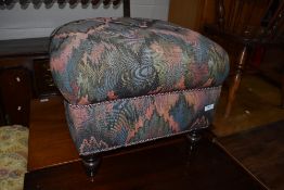 A vintage footstool on stained turned legs