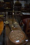 A traditional embossed copper warming pan and a set of brass balance scales