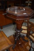 A Victorian octagonal sewing table having fitted interior, lock removed, heavily carved base