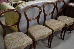A set of four Victorian mahogany balloon back chairs having later upholstery