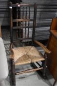 A period Lancashire spindle back rocking chair having rush seat