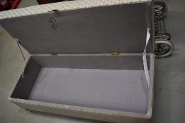 A traditional bedding box having later upholstered overstuffed seat top on bun feet and castors,