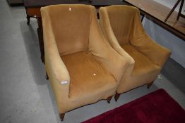 A pair of traditional armchairs having loose covers