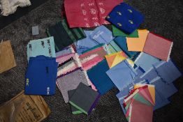 A collection of colourful fabrics from Burma, some lengths of fabric and a large assortment of