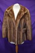 A 1960s short honey blonde mink jacket, with half belts to sides and wide collar.