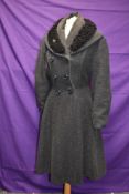 A ladies early 1950s fit and flare coat in grey wool with astrakhan collar,faux double breasted
