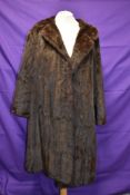 A vintage mid length brown fur coat.