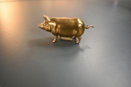 A delightful antique novelty retracting tape measure in the form of a little brass pig, twizzle