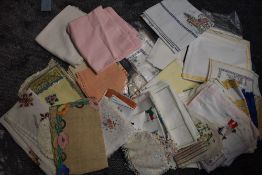 A large lot of vintage table linen,some having embroidery,also included are beaded milk jug covers.