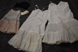 A collection of vintage petticoats one having beautiful flocked floral pattern and a long line black