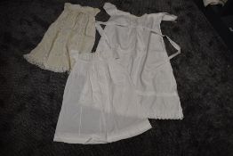 Three antique items of baby clothing including one long gown with cut work and embroidered hem,