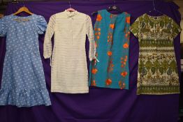 Four vintage dresses having bright patterns in a variety of fabrics and styles,small and medium