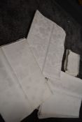 A collection of antique white table linen,including floral and grape designs.