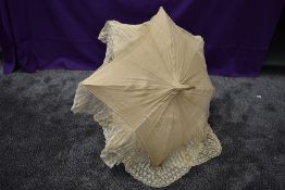 An early 20th century cream slub silk parasol with an abundance of tulle lace surrounding the