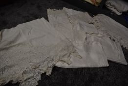 A collection of white work table linen including damask table cloths and more.