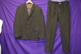 A gents 1950s single breasted tweed suit in muted green tones, fully lined, label reads; Continental