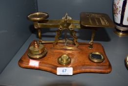 A set of antique brass post office scales reading Postal Rates for Letters with assortment of
