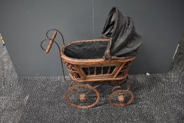A modern reproduction Victorian style Dolls Pram having wicker frame and metal wheels