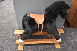 A modern Mamas & Papas plush Rocking Horse with saddle on tradition wooden swing action base