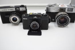 Three cameras, a Ricoh FF-1, a Konica S2, and a Russian OMO Cosmic Symbol