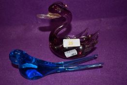 A blue glass swallow and a amethyst tinted swan.