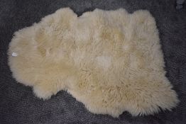 A pale colour sheep skin rug or throw