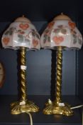 A pair of early 20th century library or desk top lights having brass twist stems with pressed pink