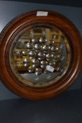 An oak framed circular Edwardian mirror having multiple bulls eye and star designs