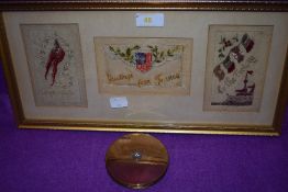 A framed selection of embroidered sweetheart postcards and a vintage compact.