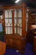 A pair of reproduction corner display cabinets, of concave form by Bevan Funnell