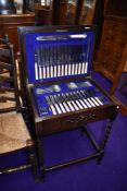 An early 20th Century oak barley twist frame canteen containing almost full set of stainless