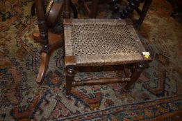 A traditional strung stool having turned frame