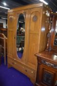 A late 19th/early 20th Century golden oak wardrobe having oval mirror door, width approx. 118cm
