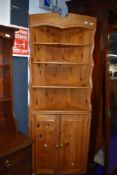 A vintage pine corner shelf with cupboard under