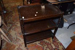 A mid 20th Century dark oak tea trolley on part twist frame