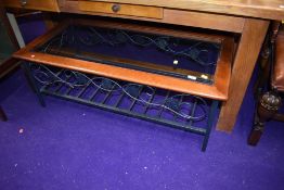 A modern glass top coffee table having metalwork frame and undertier