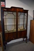 A 1920s mahogany display cabinet, on cabriole legs having ball and claw feet, approx. width 122cm,