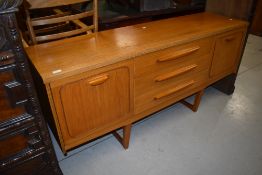 A vintage teak and laminate sideboard having stylised legs
