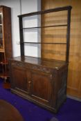 A Period oak dresser of small proportions having open delft rack , carved frieze bearing monogram