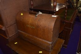 A vintage Singer sewing machine in oak case