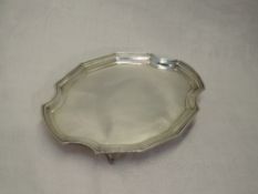 A small card tray of plain canted oval form having quatrefoil bracket feet and raised rim,London