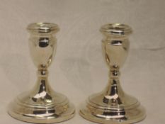 A pair of silver candle sticks of squat form on circular weighted bases, Birmingham 1971, Cooper